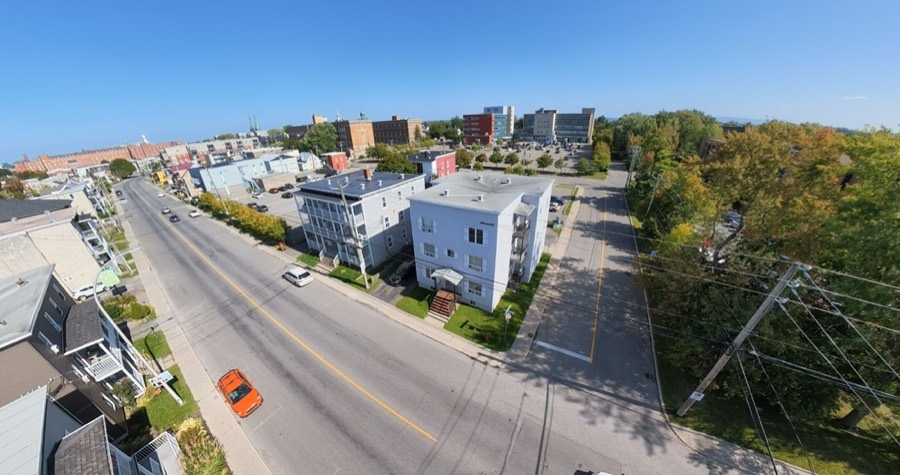 Vue aérienne de deux immeubles à logements au bord d'une avenue